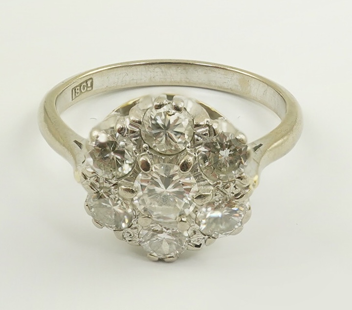 An 18ct white gold, and seven stone diamond set flower head cluster ring